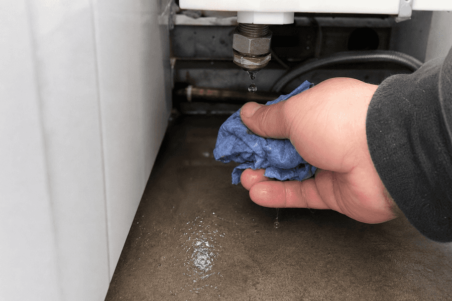 goutte sur raccord filetée et main avec chiffon